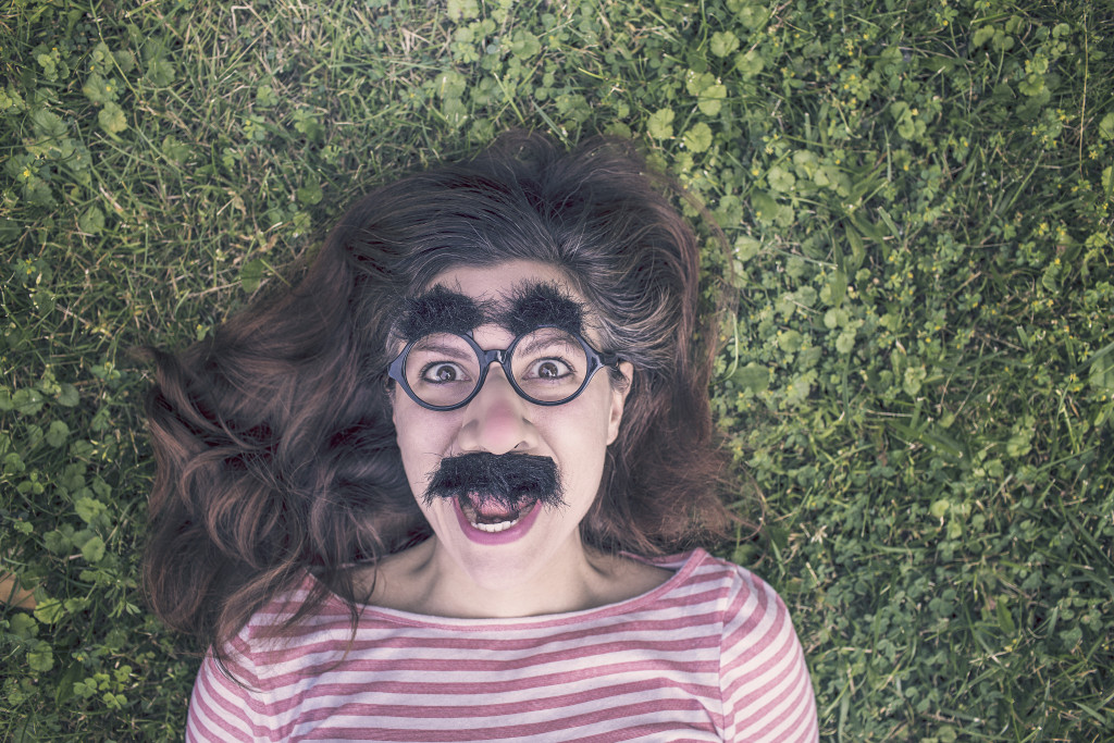 Girl lying on grass with funny glasses on